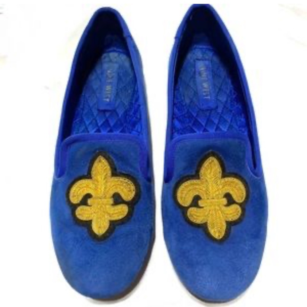 Nine West loafer with a fleur-de-lis emblem.